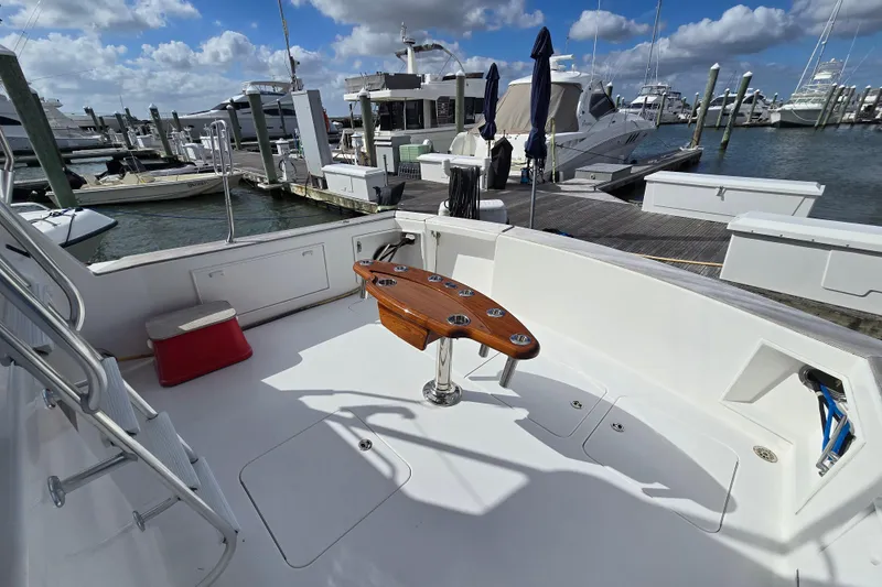 Slide: The Image of Ocean Yachts 55 Super Sport 1982, spacious deck with fishing chair, docked at marina. - 8