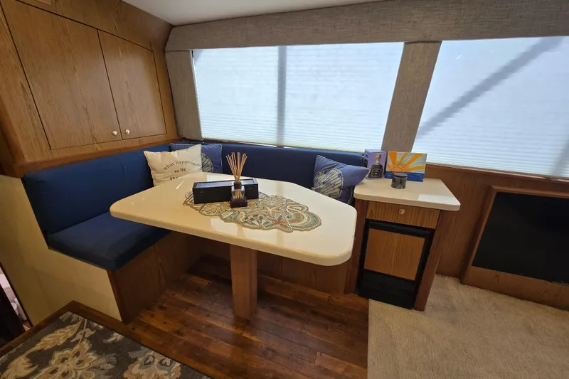 Slide: The Image of Cozy dining area in 1982 Ocean Yachts 55 Super Sport, featuring blue cushions and wooden cabinetry. - 18