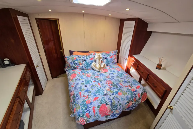 Slide: The Image of Luxurious bedroom in 1982 Ocean Yachts 55 Super Sport, featuring vibrant bedding and elegant wood finishes. - 20