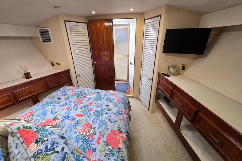 Slide: The Image of Luxurious bedroom in 1982 Ocean Yachts 55 Super Sport, featuring floral bedding and modern amenities. - 21
