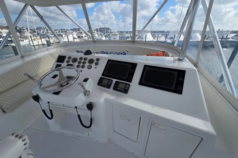 Slide: The Image of Helm of Ocean Yachts 55 Super Sport, 1982 model, with marina view. - 29