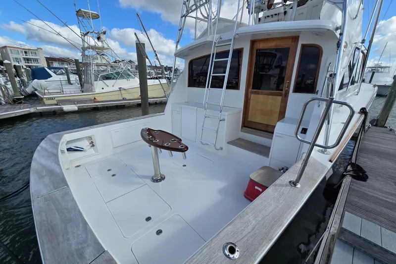 Slide: The Image of Ocean Yachts 55 Super Sport 1982 model docked, featuring spacious deck and fishing chair. - 4