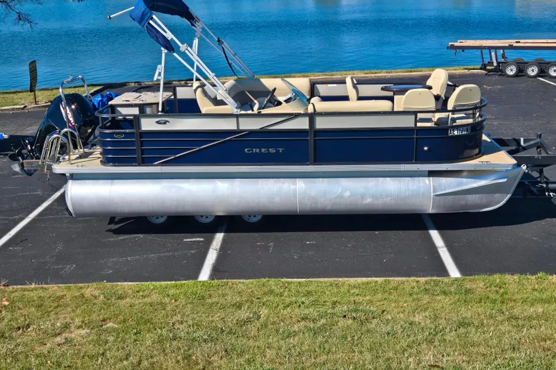 The Image of 2016 Crest II Fish 210 C4 pontoon boat parked near a serene lake. - 0