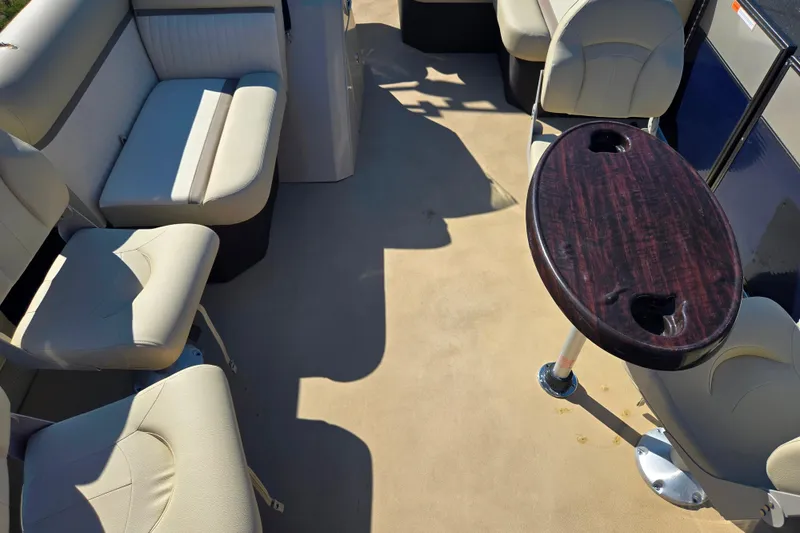 Slide: The Image of 2016 Crest II Fish 210 C4 boat interior with beige seating and a wooden table. - 10