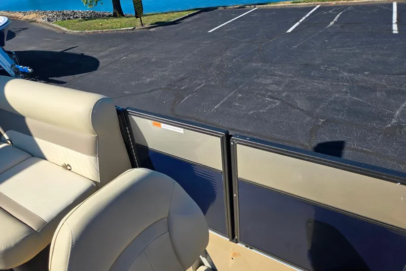 Slide: The Image of 2016 Crest II Fish 210 C4 boat interior with beige seating, parked near a lake. - 12