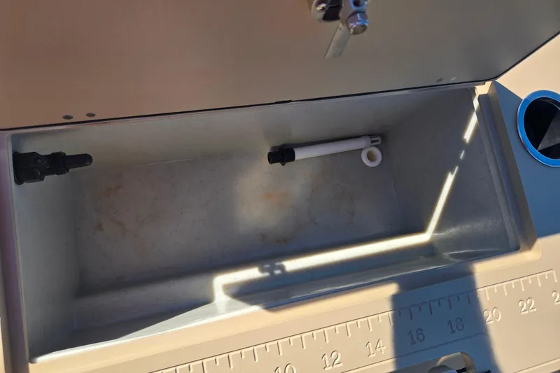 Slide: The Image of 2016 Crest II Fish 210 C4 boat storage compartment with measuring ruler. - 17