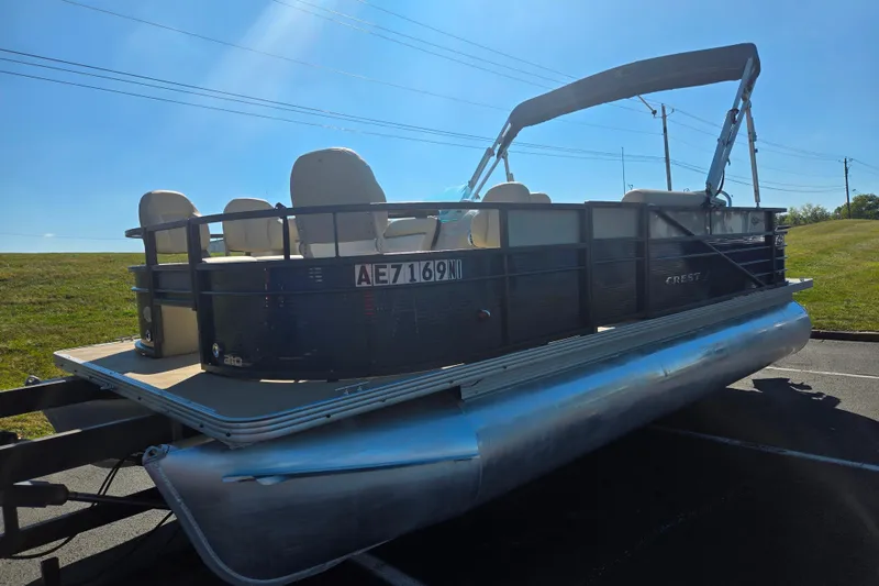 Slide: The Image of 2016 Crest II Fish 210 C4 pontoon boat on trailer under clear blue sky. - 5