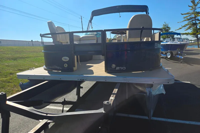 Slide: The Image of 2016 Crest II Fish 210 C4 pontoon boat on trailer, parked outdoors. - 6
