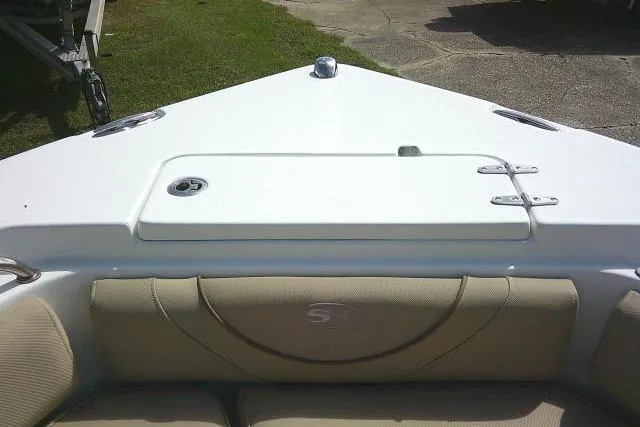Slide: The Image of 2017 Sea Hunt Ultra 235 SE boat bow with cushioned seating and storage compartment. - 15