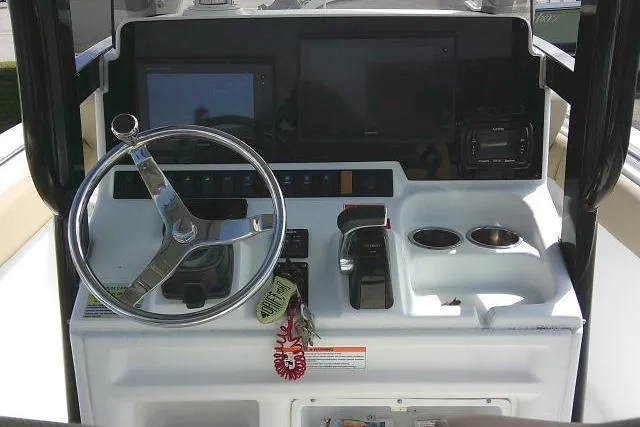 Slide: The Image of Control panel of a 2017 Sea Hunt Ultra 235 SE boat with steering wheel and displays. - 23