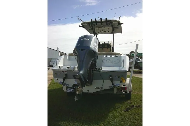 Slide: The Image of 2017 Sea Hunt Ultra 235 SE boat with powerful outboard motor, parked on grass. - 9