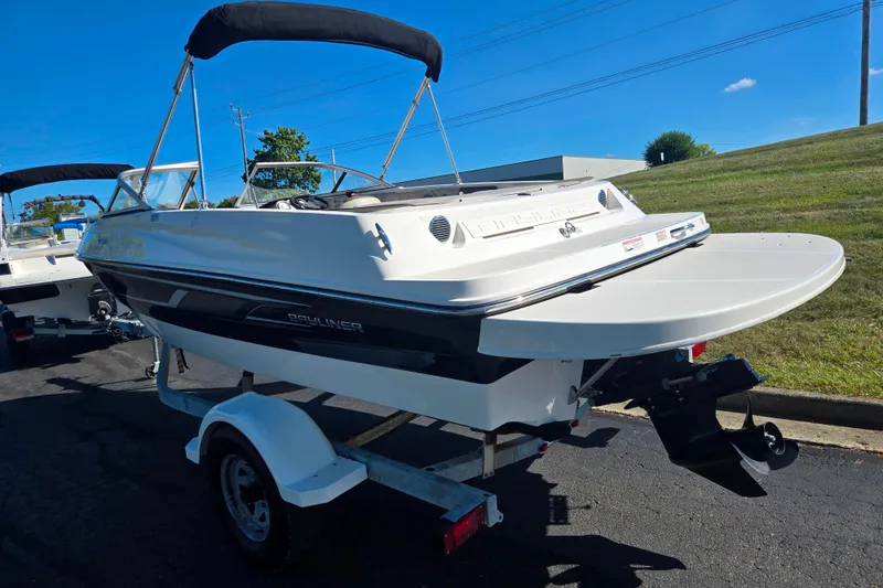 Slide: The Image of 2015 Bayliner 185 Bowrider boat on trailer, parked outdoors under clear sky. - 3