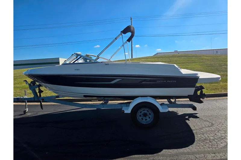 Slide: The Image of 2015 Bayliner 185 Bowrider boat on trailer, parked outdoors under clear blue sky. - 4