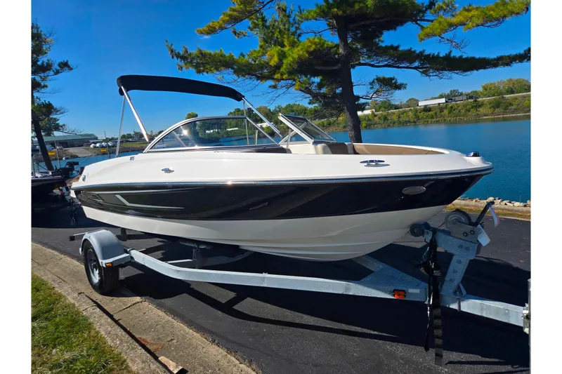 Slide: The Image of 2015 Bayliner 185 Bowrider on trailer by a scenic lake under clear blue sky. - 8