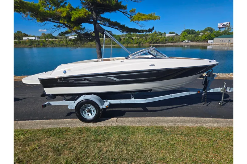 Slide: The Image of 2015 Bayliner 185 Bowrider boat on trailer by a scenic lake. - 9