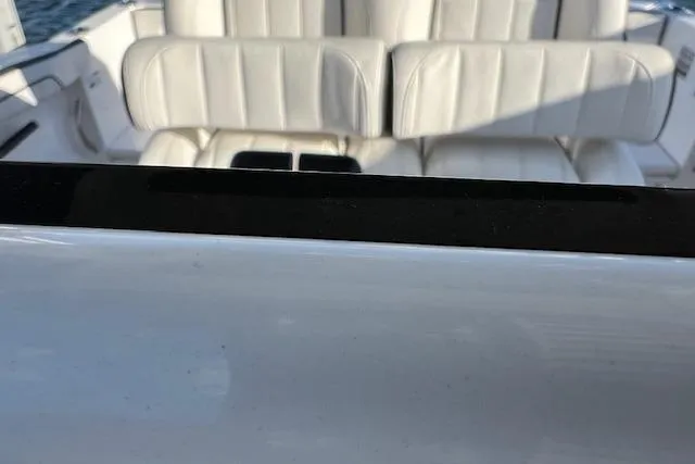 Slide: The Image of 2021 Yama 252 FSH Sport boat interior with white seating and steering wheel. - 13