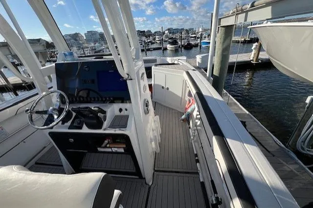 Slide: The Image of 2021 Yama 252 FSH Sport boat interior with seating, fishing gear, and American flag. - 15