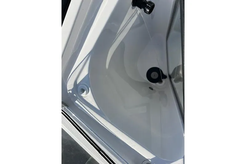 Slide: The Image of 2021 Yama 252 FSH Sport boat interior with open storage compartment, docked by the water. - 17