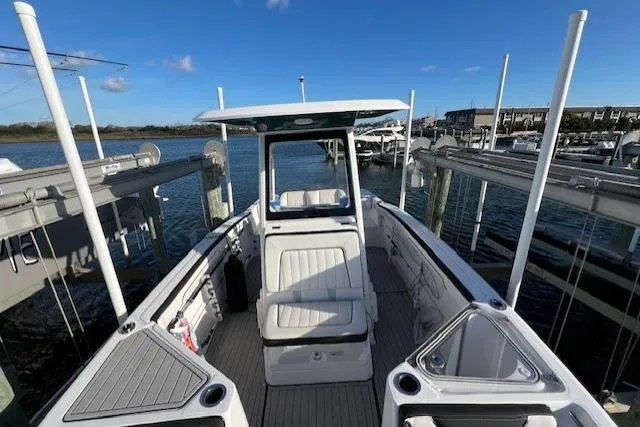 Slide: The Image of 2021 Yama 252 FSH Sport boat docked at marina under clear blue sky. - 5