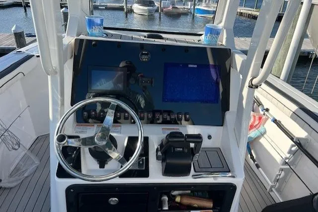 Slide: The Image of 2021 Yama 252 FSH Sport boat docked at marina under blue sky. - 8