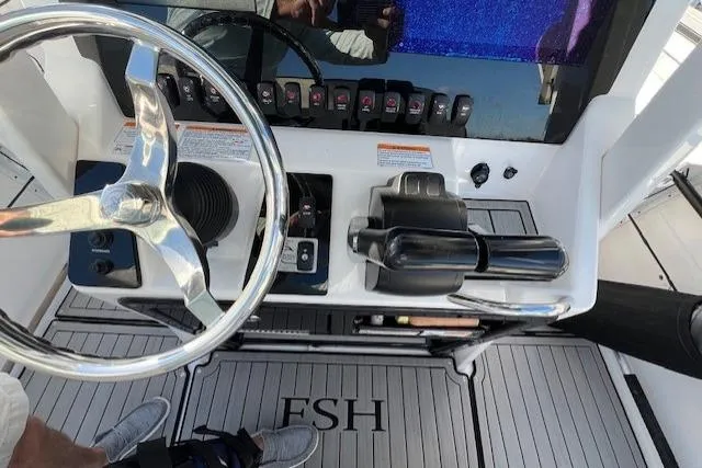 Slide: The Image of 2021 Yama 252 FSH Sport boat dashboard with steering wheel and navigation screens. - 9