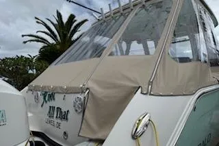 Slide: The Image of 2021 Robalo R300 Center Console boat with protective cover, palm tree in background. - 2