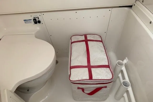 Slide: The Image of 2021 Robalo R300 Center Console boat bathroom with toilet and storage bag. - 32