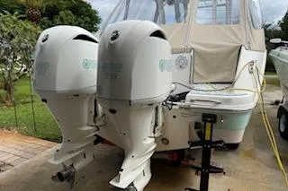 Slide: The Image of 2021 Robalo R300 Center Console boat with dual outboard engines, parked outdoors. - 4