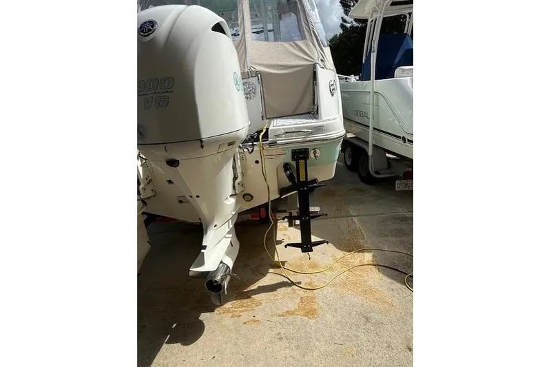 Slide: The Image of 2021 Robalo R300 Center Console boat with Yamaha outboard engine in a driveway. - 7