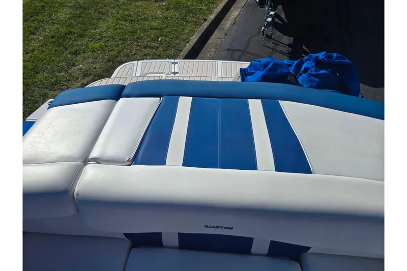 Slide: The Image of 2013 Glastron GT 205 boat with blue and white seating, docked on pavement. - 24