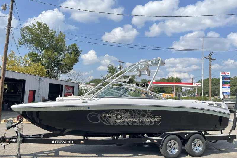 Slide: The Image of 2009 Nautique Super Air Nautique 230 boat on trailer, parked outdoors. - 1