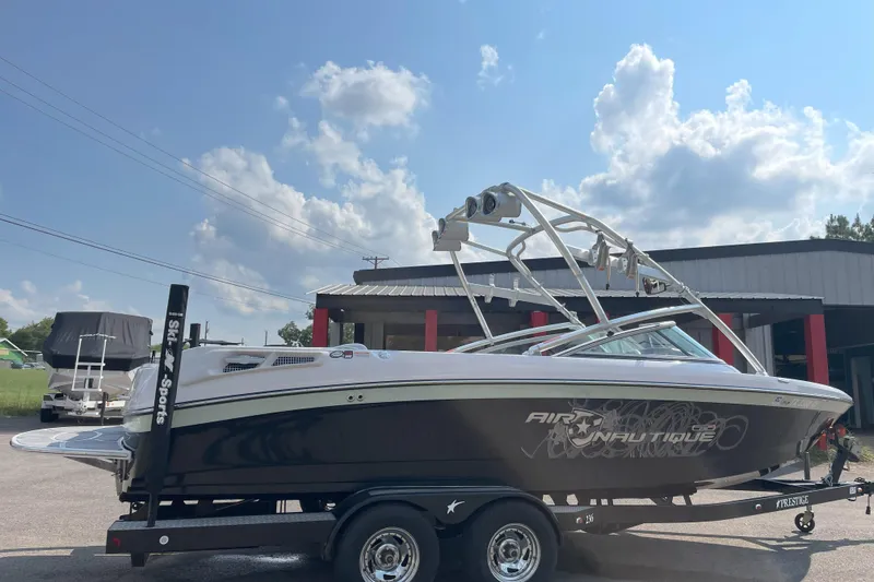 Slide: The Image of 2009 Nautique Super Air Nautique 230 boat on trailer under blue sky. - 4