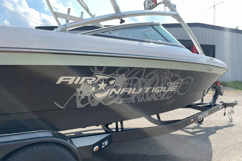 Slide: The Image of 2009 Nautique Super Air Nautique 230 boat on trailer, side view with logo. - 5