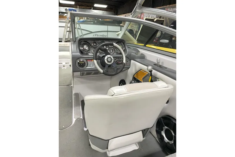 Slide: The Image of 2009 Nautique Super Air Nautique 230 boat interior with steering wheel and dashboard controls. - 7
