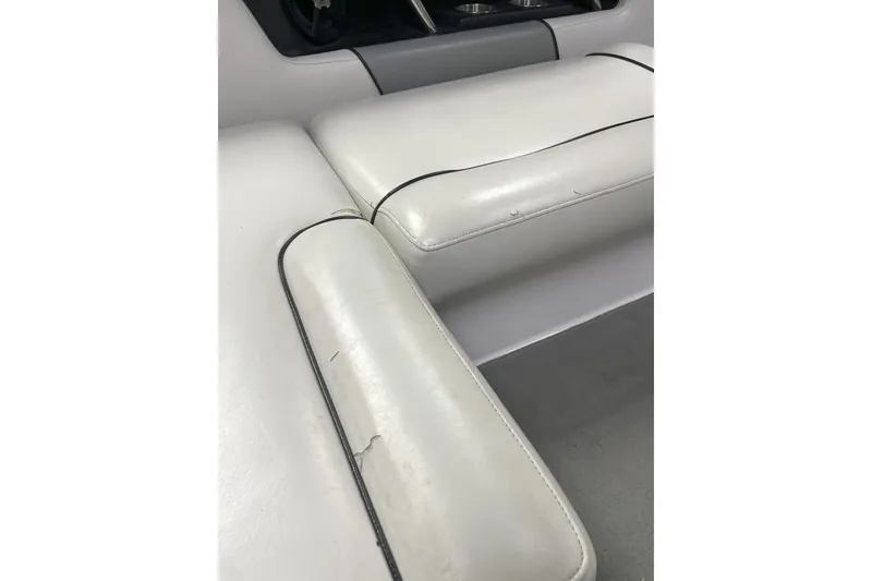 Slide: The Image of 2009 Nautique Super Air Nautique 230 interior seating with white upholstery and black trim. - 9