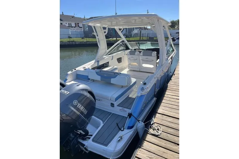 Slide: The Image of 2023 Chaparral 280 OSX boat docked, featuring Yamaha engine and spacious seating. - 1