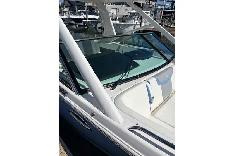 Slide: The Image of 2023 Chaparral 280 OSX boat with sleek windshield and modern design in marina setting. - 11