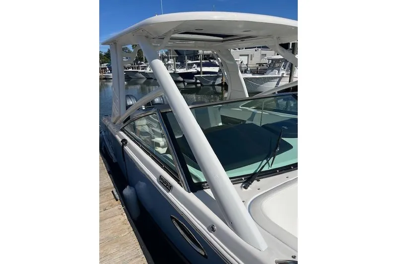 Slide: The Image of 2023 Chaparral 280 OSX boat docked at marina, showcasing sleek design and modern features. - 12