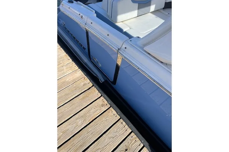 Slide: The Image of 2023 Chaparral 280 OSX boat docked, showcasing sleek design and comfortable seating. - 13