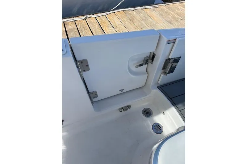 Slide: The Image of 2023 Chaparral 280 OSX boat interior, featuring a white hatch door and drainage system. - 14