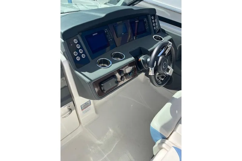 Slide: The Image of 2023 Chaparral 280 OSX boat dashboard with modern controls and steering wheel. - 17