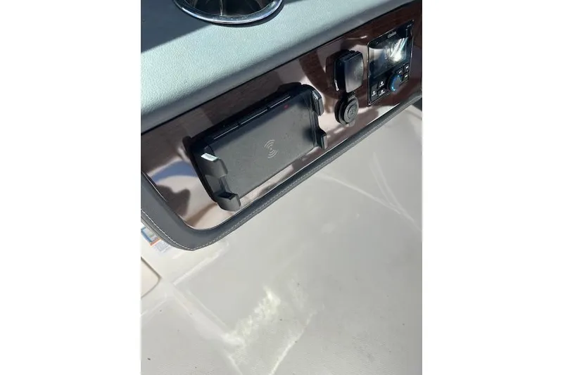 Slide: The Image of Dashboard of 2023 Chaparral 280 OSX boat with modern controls and wireless charging pad. - 20