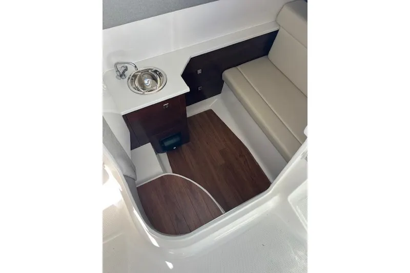 Slide: The Image of 2023 Chaparral 280 OSX interior with sink, seating, and wood flooring. - 22