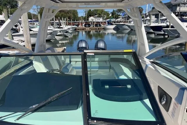 Slide: The Image of 2023 Chaparral 280 OSX boat docked at marina, showcasing sleek design and spacious interior. - 8
