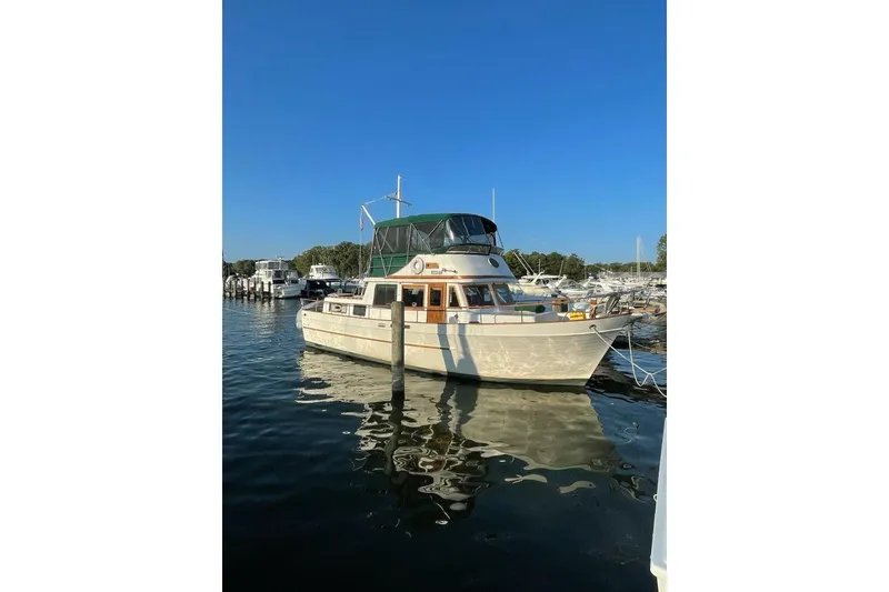 The Image of 1981 Marine Trader Double Cabin yacht docked at marina under clear blue sky. - 1
