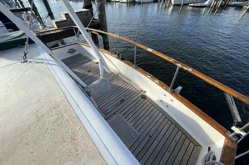 Slide: The Image of 1981 Marine Trader Double Cabin boat deck with wooden railings and dock view. - 10
