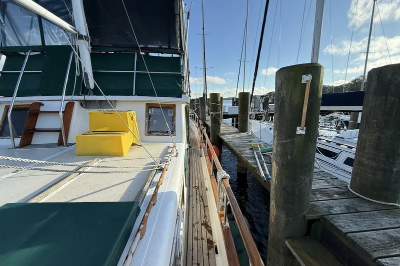 Slide: The Image of 1981 Marine Trader Double Cabin yacht docked at a marina, featuring green and yellow accents. - 14