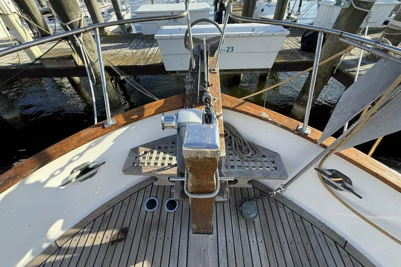 Slide: The Image of 1981 Marine Trader Double Cabin boat deck with wooden finish and metal railings at a marina. - 15