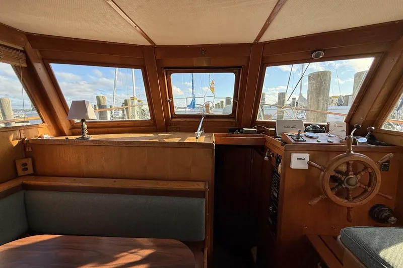 Slide: The Image of 1981 Marine Trader Double Cabin interior with wooden helm, windows, and seating area. - 19