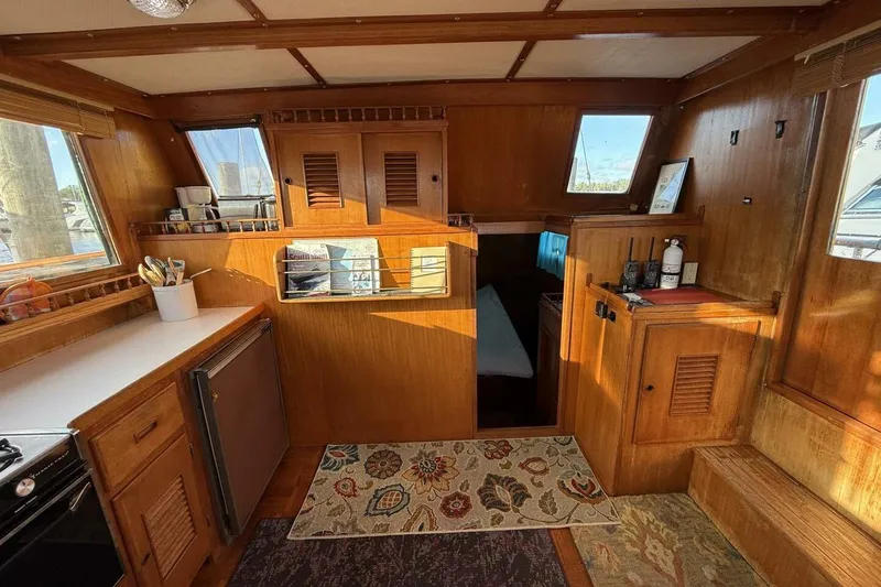 Slide: The Image of 1981 Marine Trader Double Cabin interior with wood paneling, kitchenette, and cozy decor. - 20